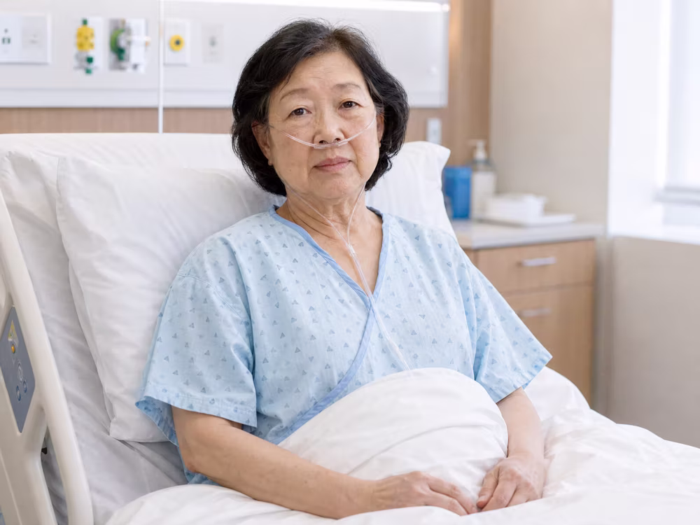 Synthetic patient Margaret Chen seated upright in a hospital bed